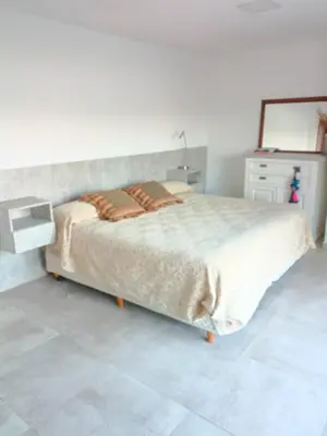 a bedroom with a large bed and a dresser at Casa lago dique los molinos in La Estancia