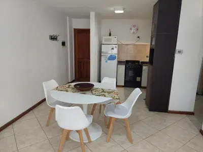 a kitchen with a white table and white chairs at Mirasol in Villa Carlos Paz