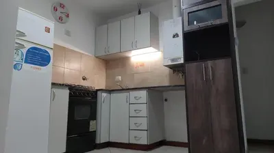 a small kitchen with white cabinets and a microwave at Mirasol in Villa Carlos Paz