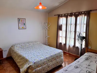 a bedroom with a bed and a window at La Casa del Gran Nogal in Villa Carlos Paz