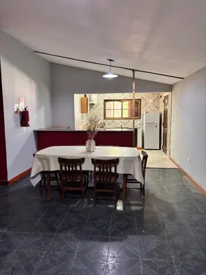 a dining room with a white table and chairs at La Casa del Gran Nogal in Villa Carlos Paz