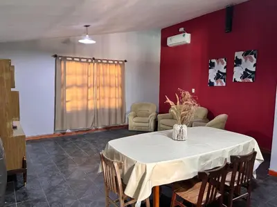 a dining room with a white table and chairs at La Casa del Gran Nogal in Villa Carlos Paz