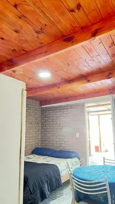 a bedroom with two beds and a wooden ceiling at Monoambiente a metros del río in Tanti