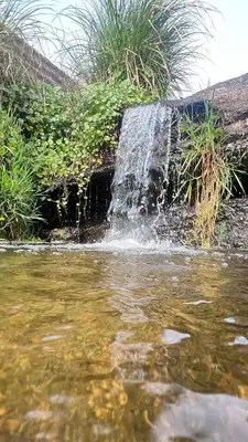 a waterfall on the side of a body of water at Monoambiente a metros del río in Tanti
