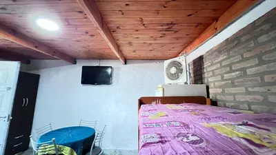 a bedroom with a bed and a tv on the wall at Monoambiente a metros del río in Tanti