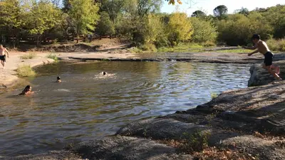 a group of people swimming in a river at Monoambiente a metros del río in Tanti