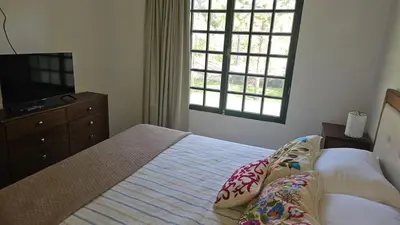 a bedroom with a bed and a dresser and a television at Chalet alaniz salinas in Cordoba