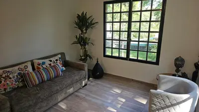 a living room with a couch and two windows at Chalet alaniz salinas in Cordoba