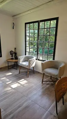 a living room with two chairs and a large window at Chalet alaniz salinas in Cordoba
