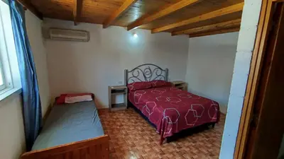 a bedroom with a red bed and a window at Departamento Don Pipo in Villa Carlos Paz