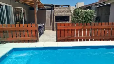 a house with a wooden fence and a swimming pool at Departamento Don Pipo in Villa Carlos Paz