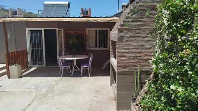 a small house with a table and chairs on a patio at Departamento Don Pipo in Villa Carlos Paz