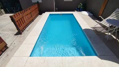 a swimming pool with blue water in a backyard at Departamento Don Pipo in Villa Carlos Paz