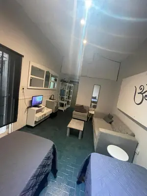 a small room with two beds and a couch at Alquiler temporario en villa Carlos Paz in Villa Carlos Paz