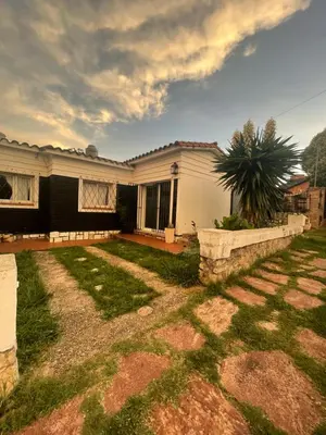 a house with a palm tree in the yard at Alquiler temporario en villa Carlos Paz in Villa Carlos Paz