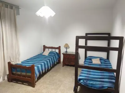 a bedroom with two bunk beds and a night stand at Casa en balneario Mayu Sumaj en cercanias de Villa Carlos Paz in San Antonio de Arredondo