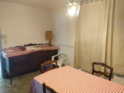 a room with two tables and a dresser and a table and chairs at Casa en balneario Mayu Sumaj en cercanias de Villa Carlos Paz in San Antonio de Arredondo