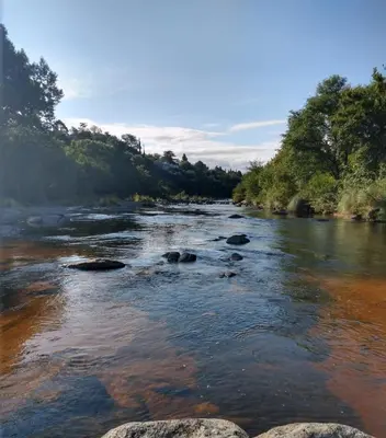 a river with rocks in the water and trees at Casa en balneario Mayu Sumaj en cercanias de Villa Carlos Paz in San Antonio de Arredondo