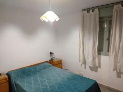 a bedroom with a blue bed and a window at Casa en balneario Mayu Sumaj en cercanias de Villa Carlos Paz in San Antonio de Arredondo