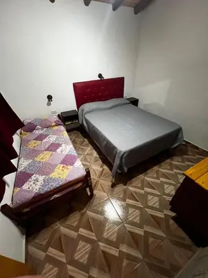 a bedroom with a bed and a quilt on the floor at Faroflor departamento in Arroyo de Los Patos