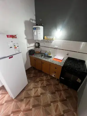 a small kitchen with a refrigerator and a sink at Faroflor departamento in Arroyo de Los Patos