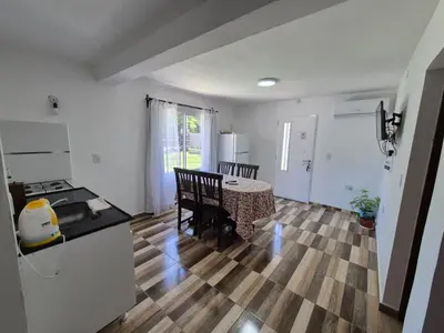 a kitchen and dining room with a table and chairs at Cabañas Colibri in Merlo