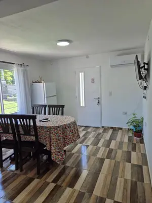 a room with a table and chairs and a refrigerator at Cabañas Colibri in Merlo