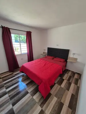 a bedroom with a bed with a red blanket on it at Cabañas Colibri in Merlo