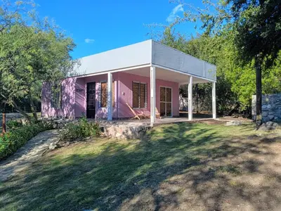 a pink house in the middle of a yard at La Berilde in La Población