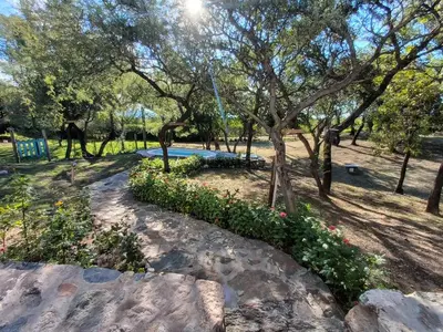 a park with a swimming pool and trees and flowers at La Berilde in La Población