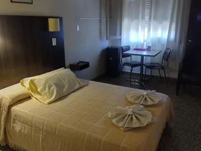 a bedroom with a bed and a table and chairs at Hotel Dunes in Villa Carlos Paz