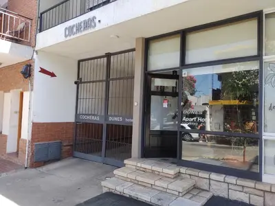 an empty store front with glass doors on a street at Hotel Dunes in Villa Carlos Paz