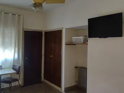 a room with a desk and a tv on a wall at Hotel Dunes in Villa Carlos Paz