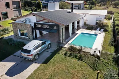 a car parked in front of a house with a pool at Señal de Amor in Villa General Belgrano