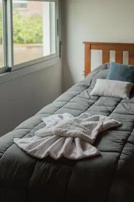 a pile of towels on a bed with a window at Señal de Amor in Villa General Belgrano