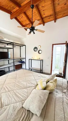 a bedroom with a large bed with a ceiling fan at Señal de Amor in Villa General Belgrano