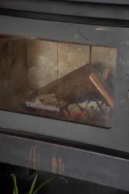 a fire in an oven with a stick in it at Señal de Amor in Villa General Belgrano