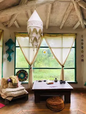a living room with a table and a large window at Cosmika, eco casa de Cosmika, eco casa de montaña in Las Calles