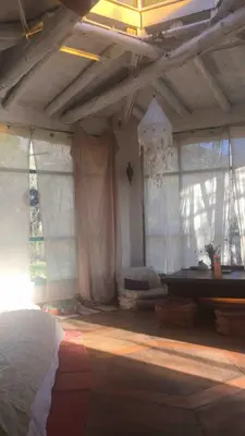 a bedroom with white curtains and a bed in a room at Cosmika, eco casa de Cosmika, eco casa de montaña in Las Calles