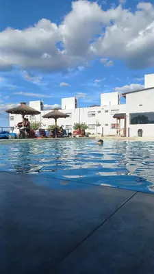 a swimming pool with umbrellas and people sitting in the water at Complejo Gran Chacha in Tanti