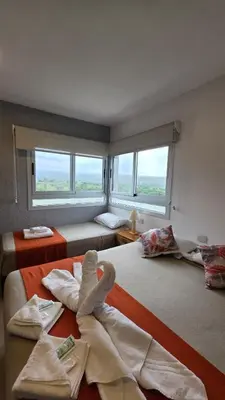 a room with two beds with towels and windows at Complejo Gran Chacha in Tanti