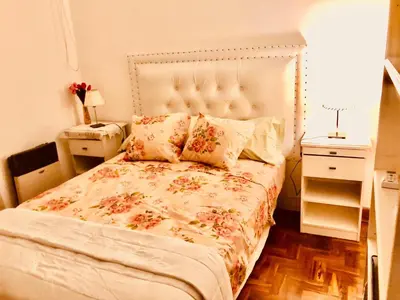 a bedroom with a bed with a floral bedspread at Habitación exclusiva Huéspedes con piscina , aire acondicionado y jardín en base doble, muy confortable in Cordoba