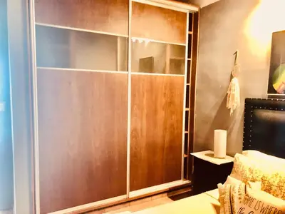 a large wooden closet in a bedroom with a bed at Habitación exclusiva Huéspedes con piscina , aire acondicionado y jardín en base doble, muy confortable in Cordoba