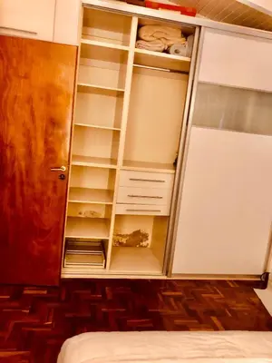 a closet with white shelves and a door at Habitación exclusiva Huéspedes con piscina , aire acondicionado y jardín en base doble, muy confortable in Cordoba