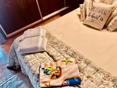 a bed with towels on top of it at Habitación exclusiva Huéspedes con piscina , aire acondicionado y jardín en base doble, muy confortable in Cordoba