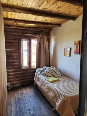 a bedroom with a bed and a window at Aruma Cabañas in Tanti