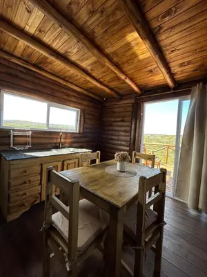 a dining room with a wooden table and chairs at Aruma Cabañas in Tanti