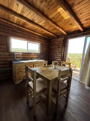 a dining room with a table and chairs in a cabin at Aruma Cabañas in Tanti