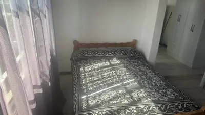 a bed with a black and white bedspread in a room at Mi casa in Villa Carlos Paz