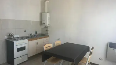 a kitchen with a table and a stove and a sink at Mi casa in Villa Carlos Paz